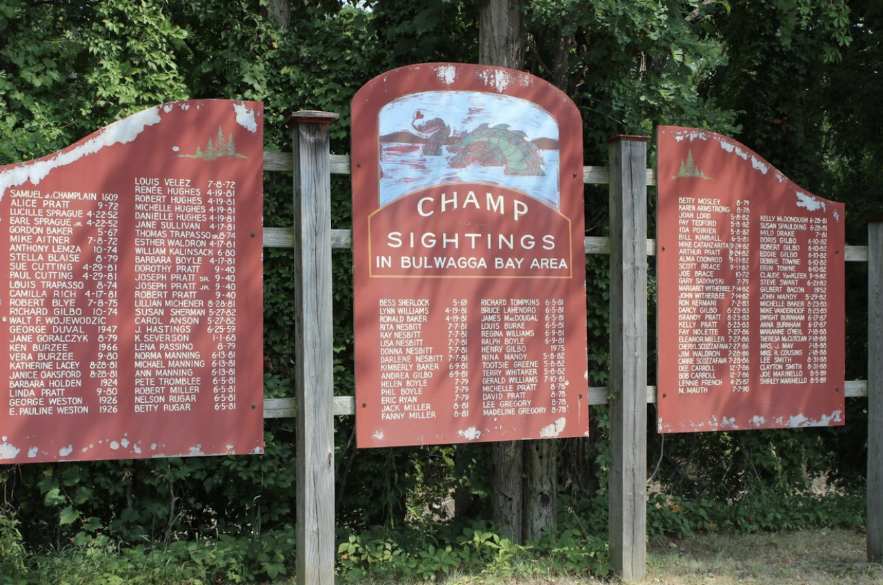 A three-panel wood sign which recognizes sightings of the mythical lake monster, Champ.